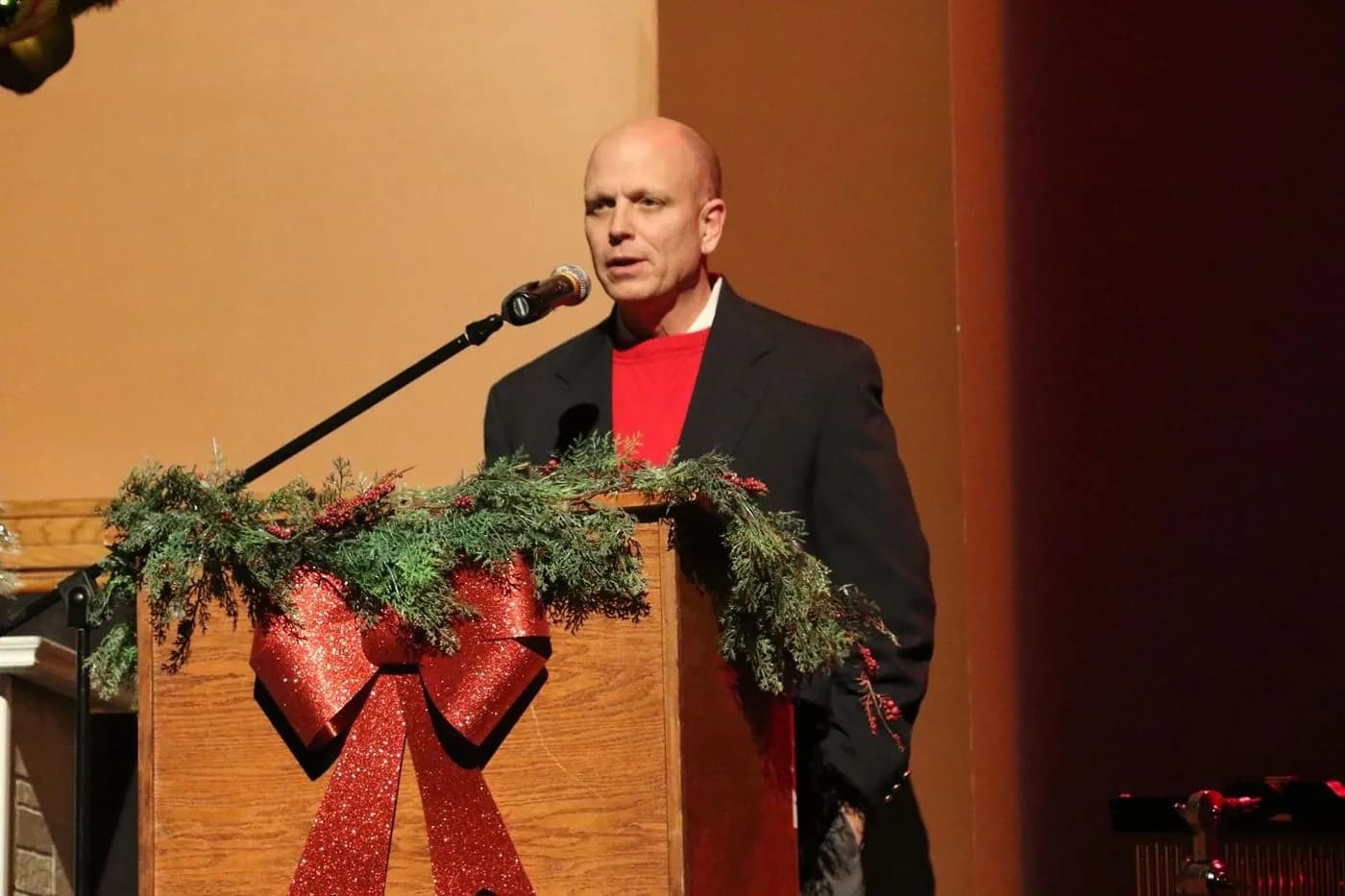 Coffman speaking from a podium at a holiday event